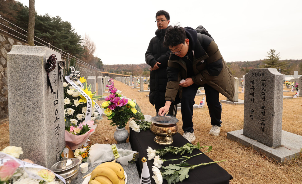 학교에서 시험을 마치고 김오랑 중령 묘역을 찾은 고등학생들이 헌화하고 있다. 신소영 기자