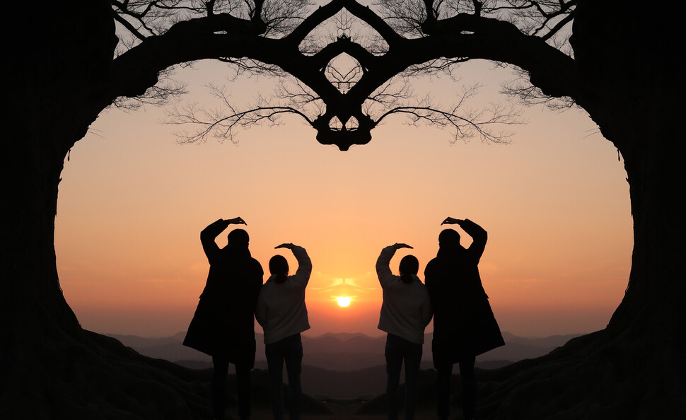 전대미문의 코로나19가 해를 넘겨 확산하는 동안, 우리는 사회적 거리두기와 고립을 선택할 수밖에 없었다. 가족 간, 친구 사이, 회사 동료 등 나와 공동체를 잇는 교류가 사라지고, 비대면 접촉이 일상화된 2021년이 저문다. 나무의 한쪽을 찍어 뒤집어 붙이면 하트 모양이 완성되어 ‘사랑나무’로 불리는 충남 부여 성흥산성(가림성) 느티나무. ‘서로’, ‘함께’여야만 하트가 완성되는 사랑나무는 우리에게 고립과 증오가 아닌 연대와 사랑의 필요를 다시금 떠올리게 한다. 높이 22m, 둘레 5.4m, 수령 400년의 성흥산 느티나무는 학술적·경관적 가치를 인정받아 지난 11월 천연기념물로 지정됐고, 영화와 드라마 촬영지로 주목받아 찾아오는 관광객의 발걸음이 이어지고 있다. 해질녘 성흥산성 ‘사랑나무’를 찾은 시민들이 하트 모양을 만들고 있다. 사진은 나뭇가지 한쪽을 데칼코마니 방식으로 편집했다. 부여/박종식 기자 anaki@hani.co.kr 전대미문의 코로나19가 해를 넘겨 확산하는 동안, 우리는 사회적 거리두기와 고립을 선택할 수밖에 없었다. 가족 간, 친구 사이, 회사 동료 등 나와 공동체를 잇는 교류가 사라지고, 비대면 접촉이 일상화된 2021년이 저문다. 나무의 한쪽을 찍어 뒤집어 붙이면 하트 모양이 완성되어 ‘사랑나무’로 불리는 충남 부여 성흥산성(가림성) 느티나무. ‘서로’, ‘함께’여야만 하트가 완성되는 사랑나무는 우리에게 고립과 증오가 아닌 연대와 사랑의 필요를 다시금 떠올리게 한다. 높이 22m, 둘레 5.4m, 수령 400년의 성흥산 느티나무는 학술적·경관적 가치를 인정받아 지난 11월 천연기념물로 지정됐고, 영화와 드라마 촬영지로 주목받아 찾아오는 관광객의 발걸음이 이어지고 있다. 해질녘 성흥산성 ‘사랑나무’를 찾은 시민들이 하트 모양을 만들고 있다. 사진은 나뭇가지 한쪽을 데칼코마니 방식으로 편집했다. 부여/박종식 기자 anaki@hani.co.kr