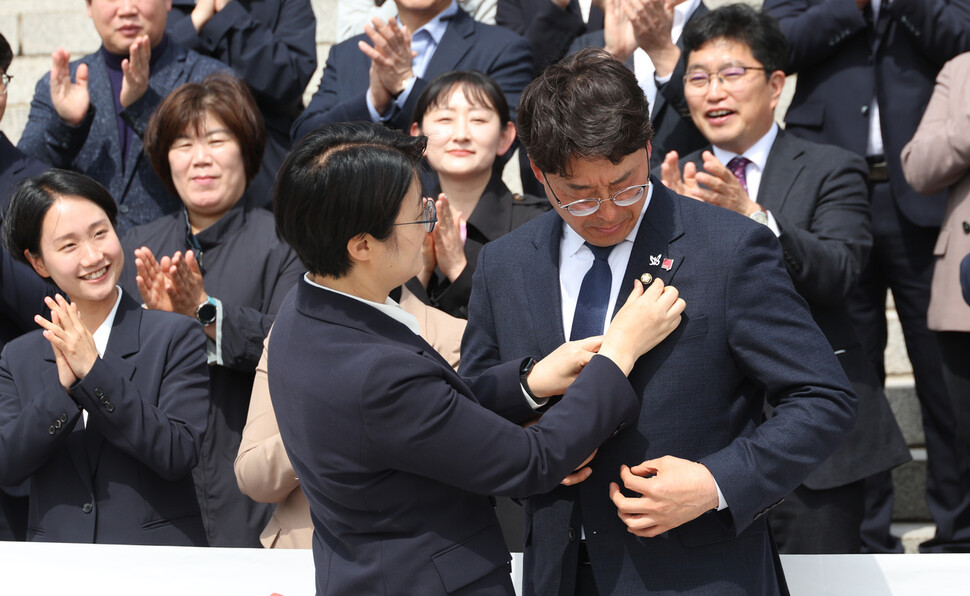 윤희숙 진보당 대표가 강성희 당선자에게 국회의원 뱃지를 달아주고 있다. 강창광 선임기자