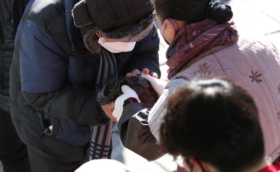 29일 오전 서울 종로구의 무료급식소에서 나눠준 미역국과 주먹밥을 한 어르신이 소중히 받아들고 있다. 박종식 기자