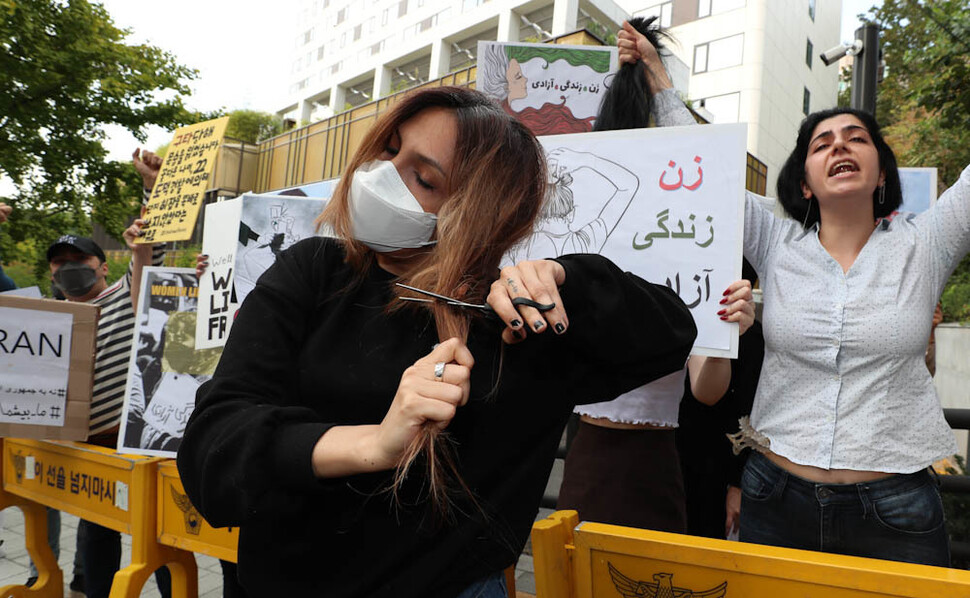 한국에 머무르고 있는 이란인들이 28일 오후 서울 용산구 주한이란이슬람공화국 대사관 인근에서 이란 당국의 히잡 반대 시위 강경 진압에 항의하는 시위를 하던 중 한 참가자가 숨진 마흐사 아미니를 추모하고 이란 내 히잡 반대 시위에 연대하는 뜻으로 자신의 머리카락을 자르고 있다. 김정효 기자