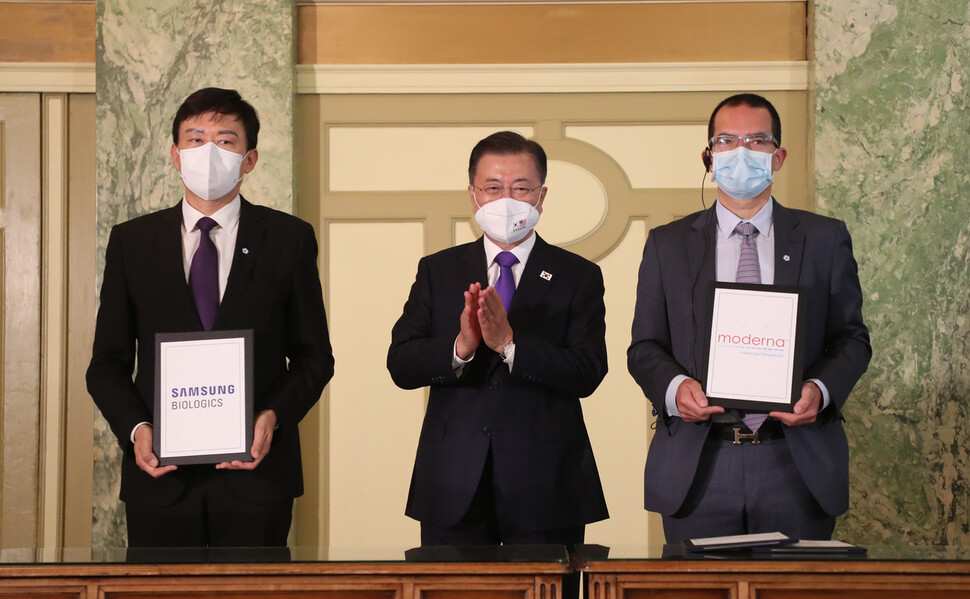 22일 오전(현지시각) 미국 워싱턴 한 호텔에서 열린 ‘한-미 백신 기업 파트너십 행사'에서 문재인 대통령이 참석한 가운데 백신 위탁생산 계약이 진행되고 있다. 왼쪽부터 존 림 삼성바이오로직스 대표, 문 대통령, 스테판 방셀 모더나 대표. 연합뉴스