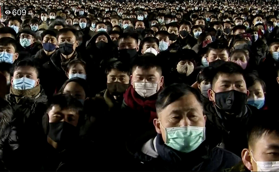 2021년 1월 1일 새벽 마스크를 쓴 북한 평양 김일성광장에서 마스크를 쓴 시민들이 국기게양식을 지켜보고 있다. 로이터 페이스북 갈무리
