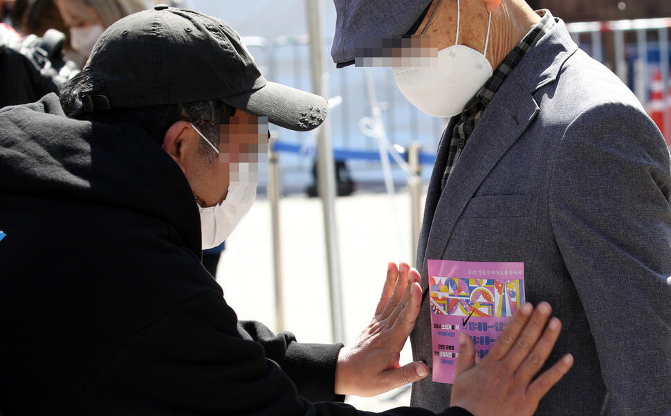 서울 여의도 윤중로의 제한적 벚꽃 관람이 시작된 5일 축제 관계자가 한 시민에게 입장 스티커를 붙여주고 있다. 김봉규 선임기자