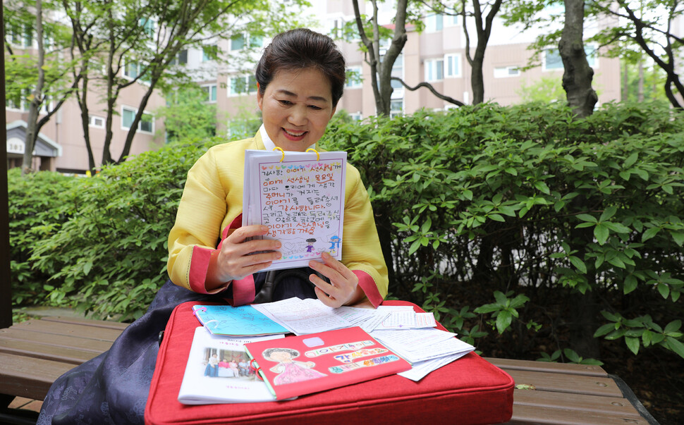 김윤숙(65) 이야기할머니가 지난 12일 오후 서울 강서구 등촌2동 집 근처 쉼터에서 아이들에게 받은 ‘감사 편지’를 읽으며 환하게 웃고 있다. 장철규 선임기자 chang21@hani.co.kr