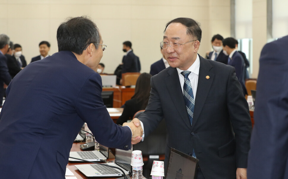 홍남기 경제부총리가 29일 오후 서울 여의도 국회에서 기재위 전체회의가 끝난 후 미래통합당 추경호 간사와 악수하고 있다. 연합뉴스