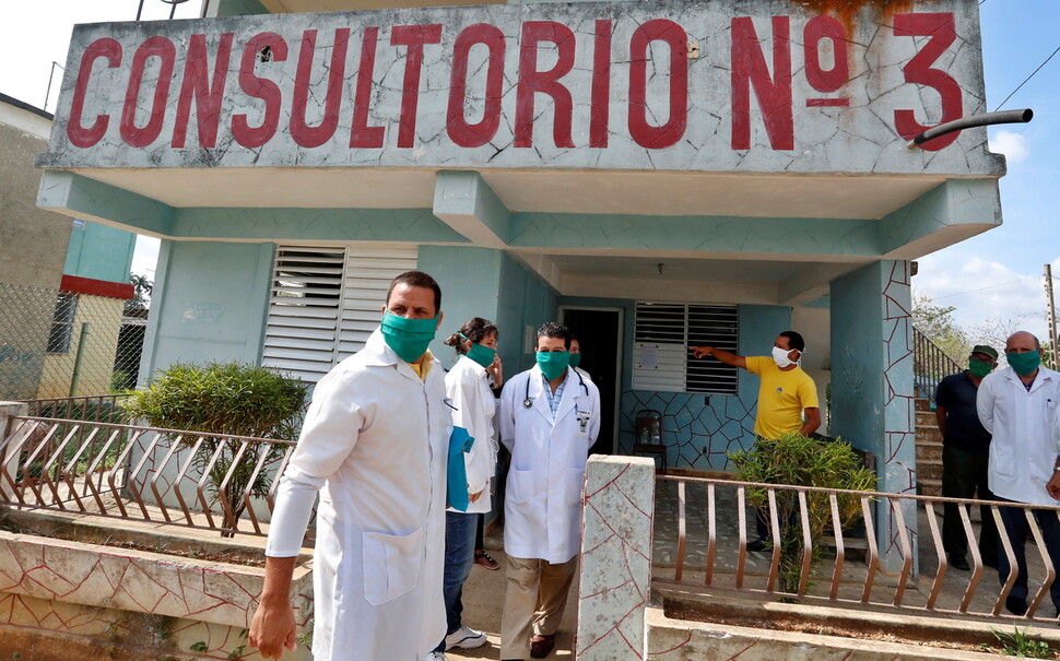 지난 4월 쿠바 산호세데라스라하스 ‘가족주치의 진료소’에 모인 의사들이 건물 밖으로 나와 코로나19 방역을 논의하는 모습이다. AP 연합뉴스