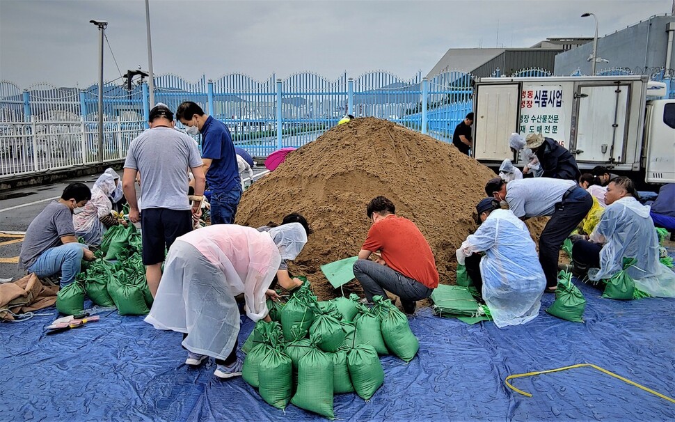 5일 오후 마산항 연안크루즈터미널에서 마산어시장 등 경남 창원시 마산합포구 해안지역 소상공인들이 태풍 힌남노에 대비해 가게 입구에 쌓을 모래주머니를 만들고 있다. 최상원 기자