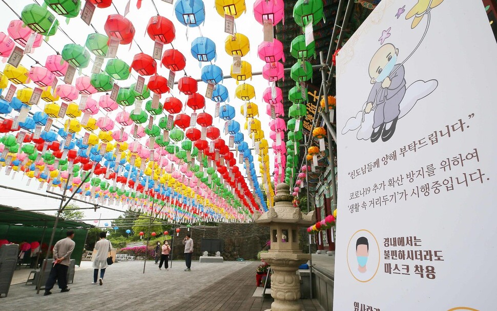 코로나19 여파로 연기됐던 부처님오신날 봉축법요식이 열린 30일 제주 관음정사에서 신도들이 마스크를 쓰고 경내를 다니고 있다. 연합뉴스