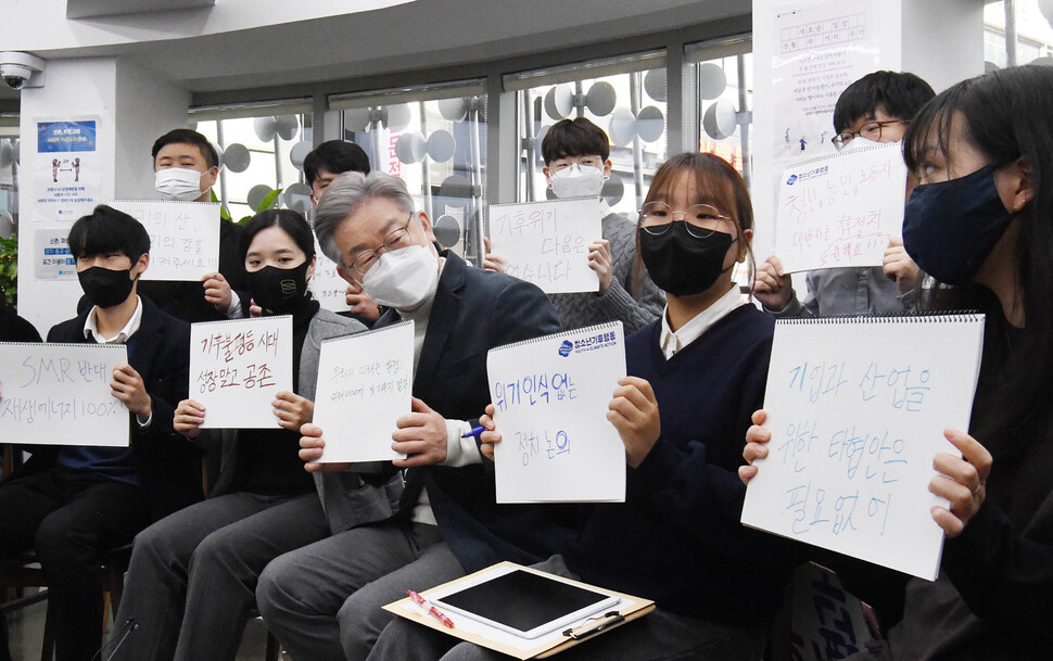 더불어민주당 이재명 대선 후보가 16일 오전 서울 서대문구 청년문화공간 신촌 파랑고래에서 열린 청소년ㆍ청년 기후활동가 간담회에서 참석자들과 구호가 적힌 손팻말을 들고 있다.국회공동사진취재단/연합뉴스