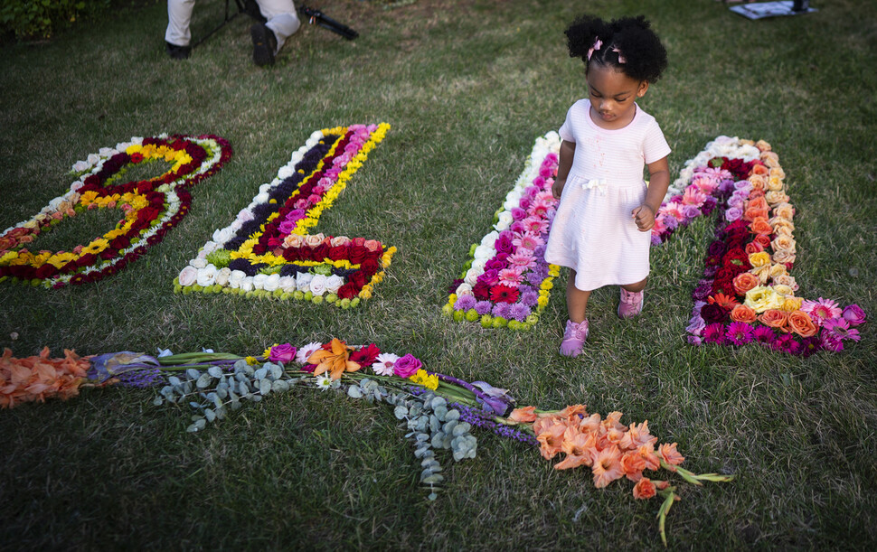 지난 6일 미국 미네소타주 필랜도 캐스틸 기념관 안에서 한 소녀가 ‘흑인의 생명은 소중하다’라는 뜻의 ‘BLM’을 꽃으로 새겨둔 잔디밭을 걷고 있다. 캐스틸은 4년 전 경찰관의 총에 맞아 치명상을 입었다. 연합뉴스