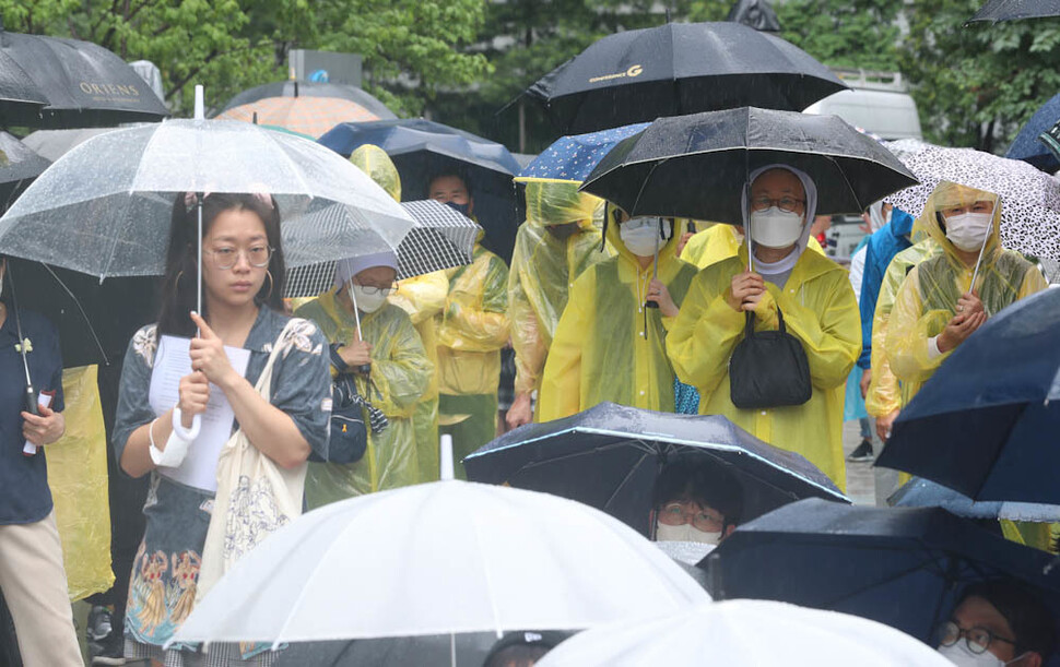 장맛비가 내린 29일 오후 서울 종로구 옛 일본대사관 앞 평화로에서 열린 ‘제1550차 일본군 성노예제 문제 해결을 위한 정기 수요시위’ 참가자들이 일본의 사과와 배상을 요구하고 있다. 김정효 기자