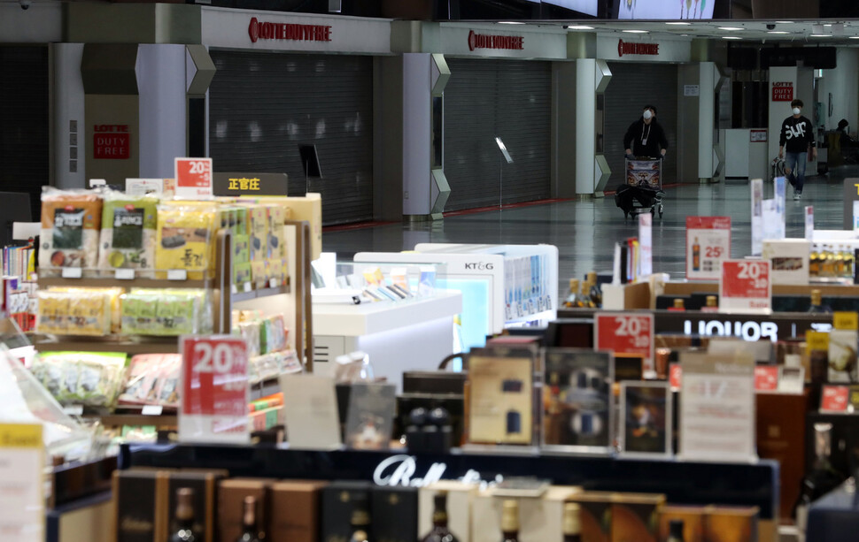 코로나19 여파로 김포공항 내 운영 중인 롯데면세점이 휴점에 돌입한 12일 김포국제공항 국제선 청사 내 롯데면세점의 셔터 문이 내려가 있는 반면 신라면세점은 정상운영을 하고 있다. 공동취재사진