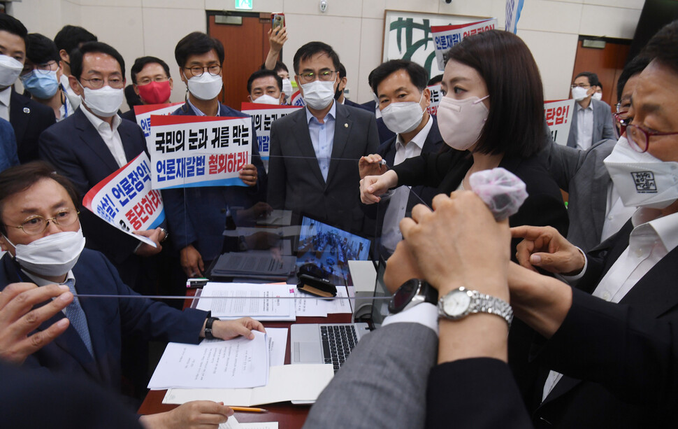 국회 문화체육관광위원회 국민의힘 이달곤 간사(오른쪽)와 의원들이 19일 서울 여의도 국회 문화체육관광위원회 전체회의에서 언론중재법 개정안을 의결하려는 도종환 위원장(왼쪽)의 회의 진행을 막고 있다. 연합뉴스