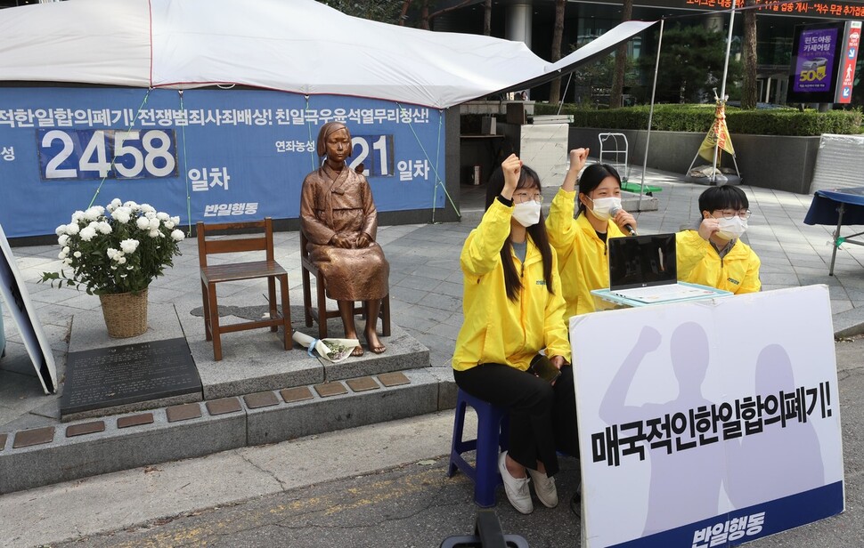 21일 낮 서울 종로구 중학동 주한 옛 일본대사관 앞에서 제1562차 일본군성노예제 문제해결을 위한 정기 수요시위가 열리는 동안 소녀상을 지키고 있는 반아베반일청년학생공동행동(반일행동) 활동가들이 구호를 외치고 있다. 강창광 선임기자