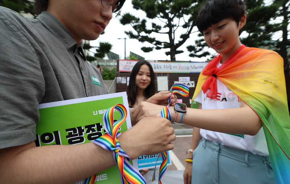 ‘성공회대 미니퀴어퍼레이드 조직위원회’ 소속 단체 학생 등이 20일 오전 서울 구로구 성공회대 나눔관 광장에서 기자회견을 열어 서울퀴어문화축제에 서울광장 사용을 불허한 서울시를 비판하고, 대학 최초로 학내에서 ‘미니퀴어축제’를 연다고 밝힌 뒤 축제 시작을 알리는 뜻에서 무지개 빛깔의 띠를 잘라 서로의 손목에 묶어주고 있다. 김정효 기자