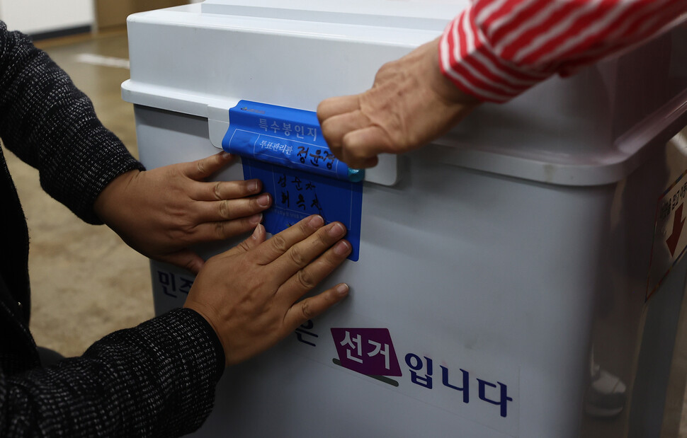 서울시장 보궐선거일인 7일 오전 중계본동 제3투표소에서 선관위 관계자와 투표참관인들이 투표함 봉인 작업을 하고 있다. 연합뉴스
