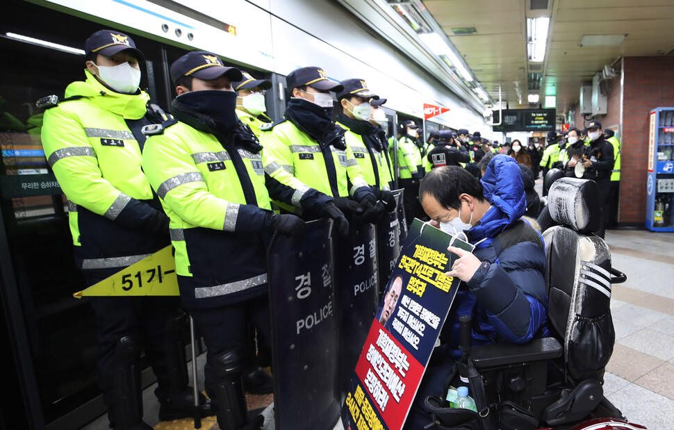 전국장애인차별철폐연대(전장연) 회원들이 2일 오전 서울 지하철 4호선 삼각지역 승강장에서 지하철 탑승을 시도하는 가운데 경찰이 배치돼 있다. 신소영 기자 viator@hani.co.kr