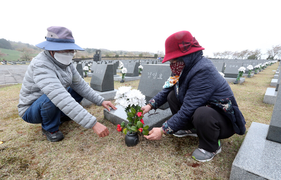 2일 오전 제주 봉개동 4.3평화공원내 행불자묘소에서 김은자씨 가족이 아버지 김영효씨를 애도하며 참배룰 동백꽃을 화병에 꽂고 있다. 제주/이정용 선임기자