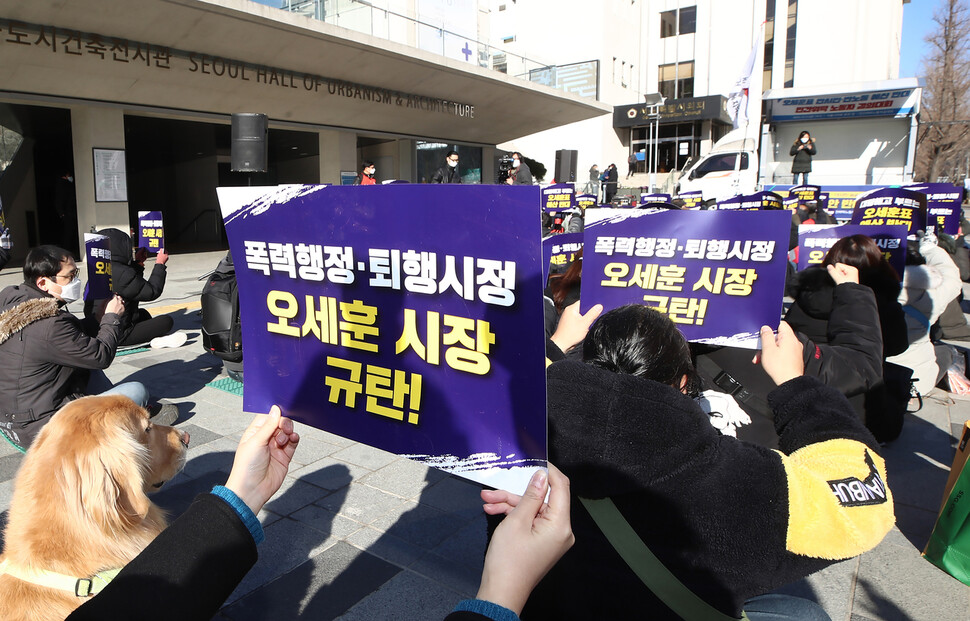 민간위탁노동자공대위 노동자들이 지난 3일 오전 서울 중구 서울시의회 본관 앞에서 열린 오세훈표 반시민·반노동 예산 반대 민간위탁 노동자 결의대회에서 손팻말을 들고 있다.연합뉴스