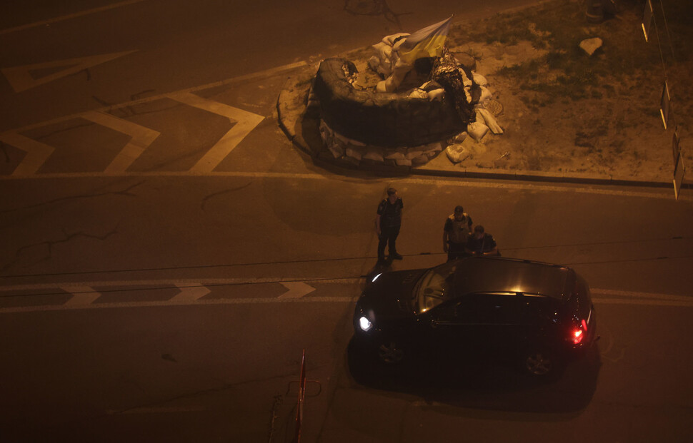 우크라이나 키이우의 한 거리에 설치된 임시초소에서 통행금지가 시작되자 경찰들이 지나가던 차를 검문하고 있다. 키이우/김혜윤 기자