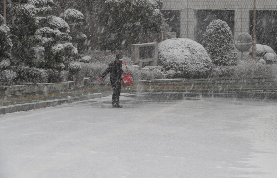 28일 오전 서울 서대문구 서울시교육청에서 직원이 염화나트륨을 뿌리며 제설 작업을 하고 있다. 김혜윤 기자 unique@hani.co.kr