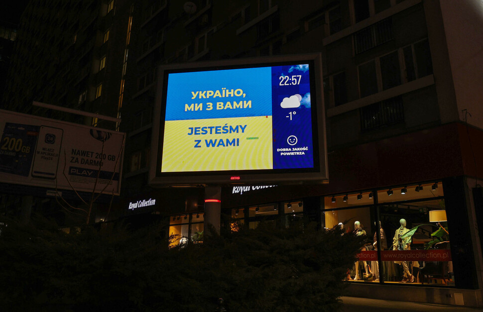 5일 저녁(현지시각) 폴란드 바르샤바 중앙역 인근 전광판에 우크라이나 국기와 함께 ‘우리는 당신과 함께 있습니다’라는 응원 문구가 보이고 있다. 바르샤바/김혜윤 기자