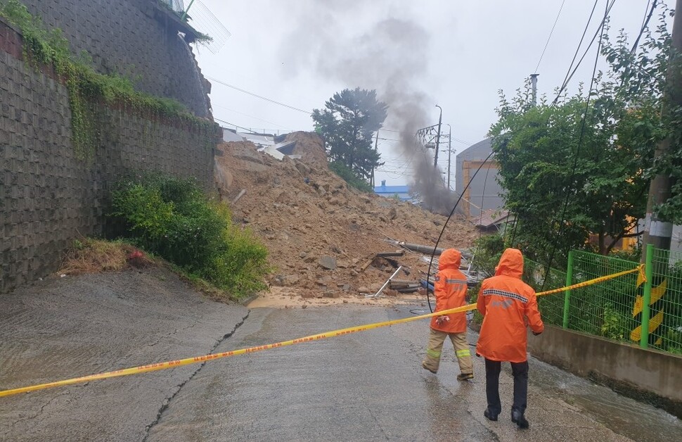 21일 오후 경남 양산시 장기터2길 공장 일대에서 옹벽이 무너지며 도로 위로 토사가 쏟아져 소방당국 관계자들이 현장을 통제하고 있다. 경남도소방본부 제공