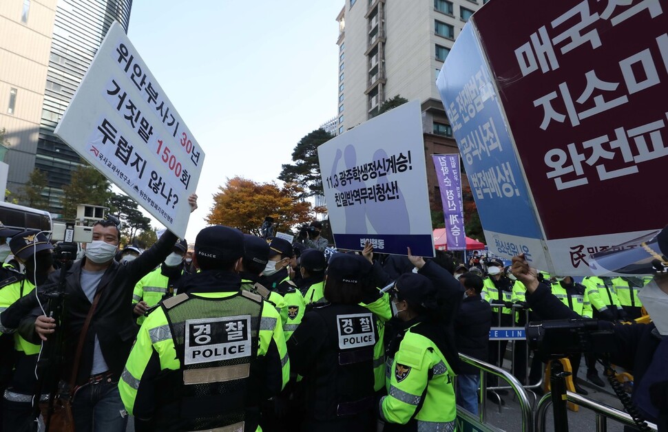 평화의 소녀상 앞에서 보수단체 회원들과 반일행동 회원이 경찰을 사이에 둔 채 손팻말 시위를 벌이고 있다.