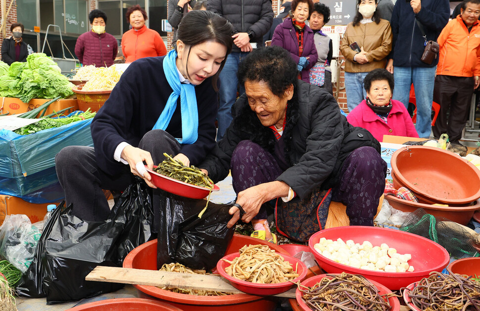 김건희 여사가 7일 오후 전남 순천시 풍덕동 아랫장을 방문해 한 상인에게 나물을 구매하고 있다. 대통령실사진기자단