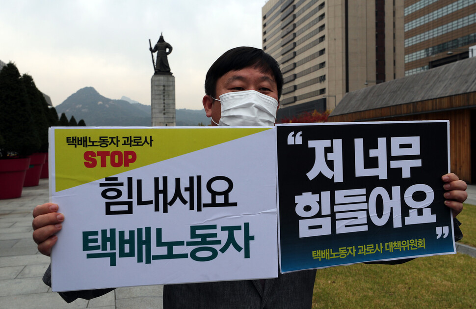 ‘택배노동자 죽음의 행렬을 끊기 위한 각계 대표단 공동선언 발표 기자회견’에서 한 참가자가 손팻말을 들고 있다. 이종근 선임기자