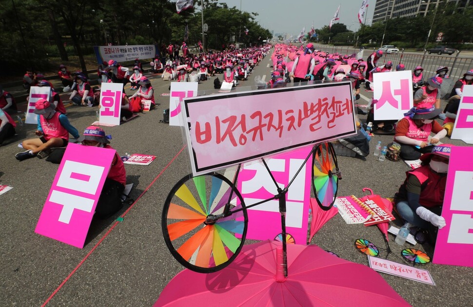 학교 비정규직 노동자들이 비정규직 차별철폐 적힌 우산을 들고 있다. 박종식 기자