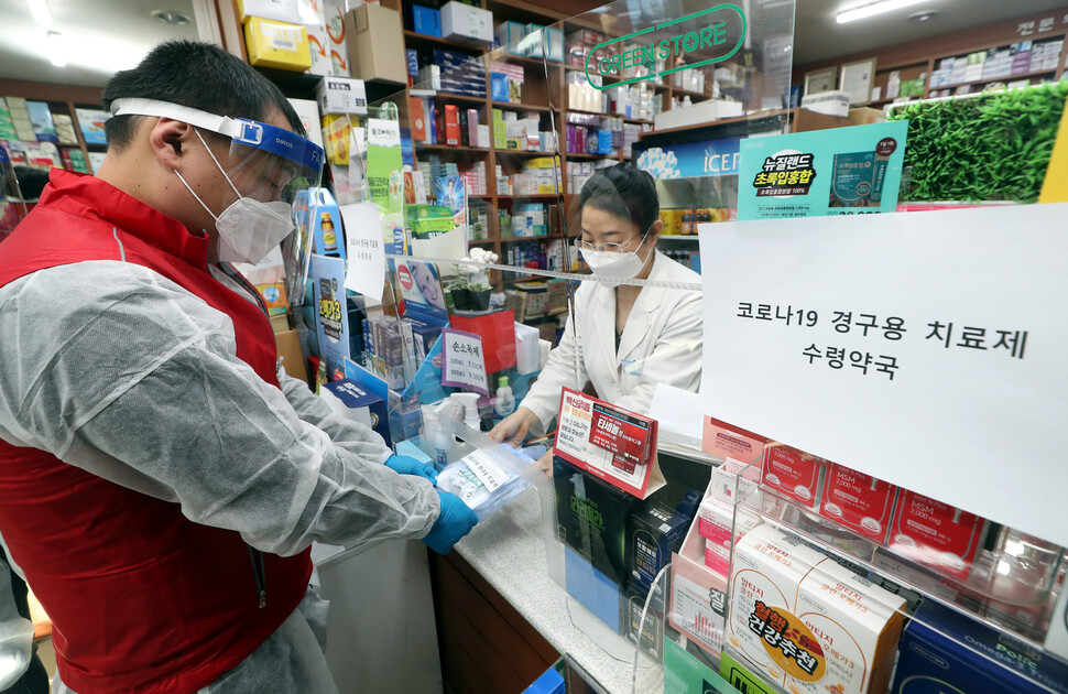 12일 오전 인천시 부평구 한 약국에서 열린 ''신종 코로나바이러스 감염증(코로나19) 경구용(먹는) 치료제 투약 예행 연습''에서 부평구보건소 관계자가 치료제를 약국에서 수령해 환자에게 전달하는 연습을 하고 있다. 정부는 코로나19 경구용 치료제를 이달 14일부터 각 환자에게 투약할 방침이다. 2022.1.12 인천/연합뉴스