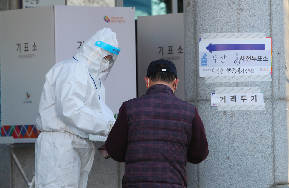 5일 오후 대구 수성구 두산동행정복지센터 사전투표소에서 코로나19 확진자 혹은 격리자가 투표 용지를 받고 있다. 연합뉴스