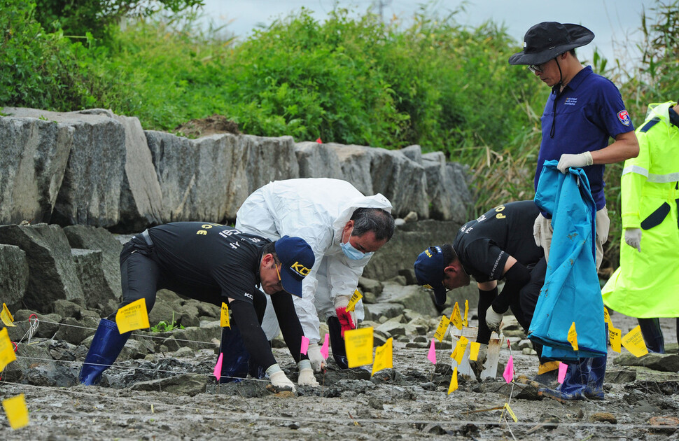 2014년 8월21일 전북경찰청 과학수사대(CSI) 직원들이 전북 망성면 화산리 황산대교 아래 금강변에서 유해를 발굴하고 있다. 연합뉴스