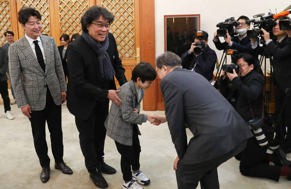 문재인 대통령과 부인 김정숙 여사가 20일 오전 청와대 본관 충무전실에서 지난해 칸영화제 황금종려상에 이어 올해 아카데미 작품상, 감독상 등 4개 부문 상을 받은 영화 &lt;기생충&gt;을 만든 봉준호 감독과 배우, 제작진을 만나 인사하고 있다. 문 대통령이 악수하는 이는 아역 배우 정현준군이다. 김정효 기자