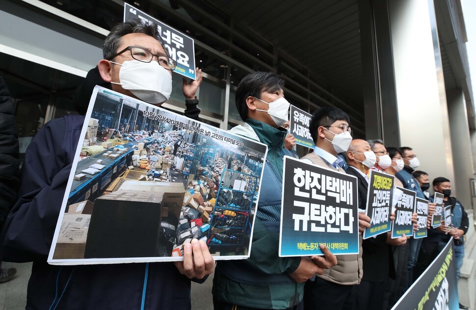 19일 오전 서울 중구 한진택배 본사 앞에서 열린 한진택배 규탄 기자회견에서 한 참석자가 과로사로 세상을 떠난 택배노동자 김아무개씨가 일한 물류센터의 모습을 찍은 사진을 들고 있다. 백소아 기자