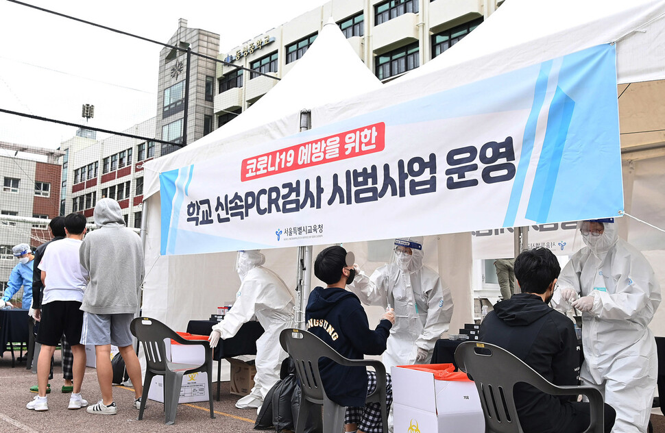 28일 오전 서울 종로구 동성고등학교에서 학생들이 등교하며 코로나19 신속 자가분자진단 유전자증폭(신속 PCR) 검사를 받고 있다. 사진공동취재단