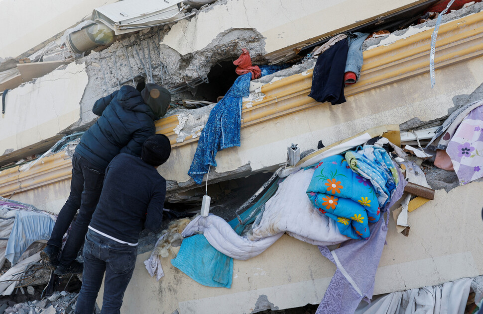 7일(현지시각) 튀르키예 남동부의 카흐라만마라스에서 시민들이 무너진 건물 잔해 사이를 살피고 있다. 카흐라만마라스[튀르키예]/로이터 연합뉴스