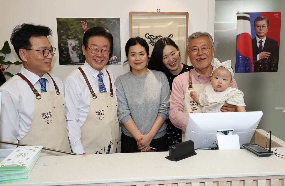 이재명 더불어민주당 대표와 문재인 전 대통령이 책방을 찾은 한 가족과 기념사진을 찍고 있다. 강창광 선임기자