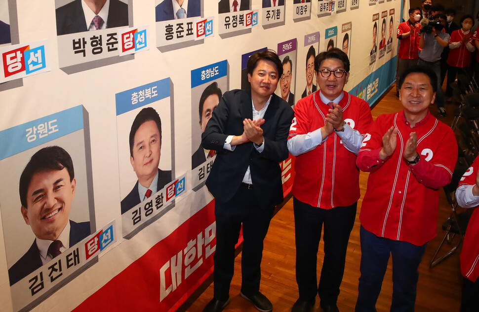 이준석 국민의힘 대표와 지도부가 1일 오후 국회 도서관 대강당에 마련된 지방선거 개표상황실에서 당선이 유력시되는 단체장 후보 사진 밑에 스티커를 붙인 뒤 박수치고 있다. 국회사진기자단