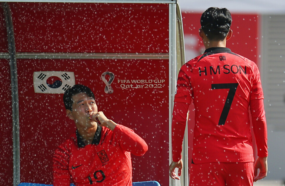 한국 남자축구 대표팀 주장 손흥민(오른쪽)이 16일(현지시각) 오전 카타르 도하 알 에글라 훈련장에서 얼굴 부상 회복을 위해 마스크를 쓴 모습을 김영권이 지켜보고 있다. 도하/김혜윤 기자 unique@hani.co.kr