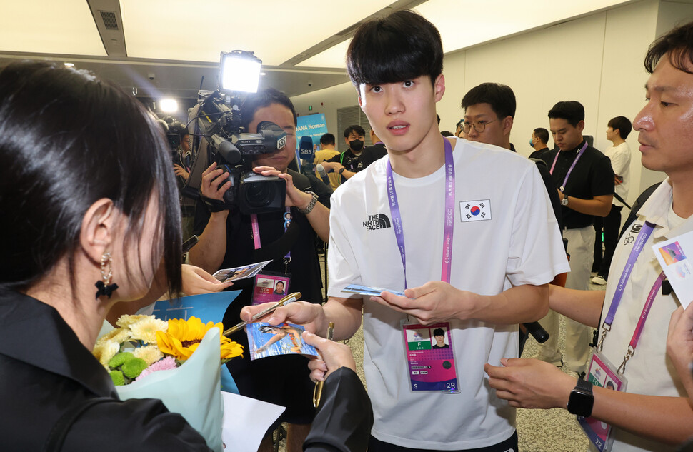 항저우아시안게임에 출전하는 수영 대표팀 황선우가 21일 중국 항저우 샤오산 국제공항으로 입국해 팬에게 사인해 주고 있다. 항저우/연합뉴스