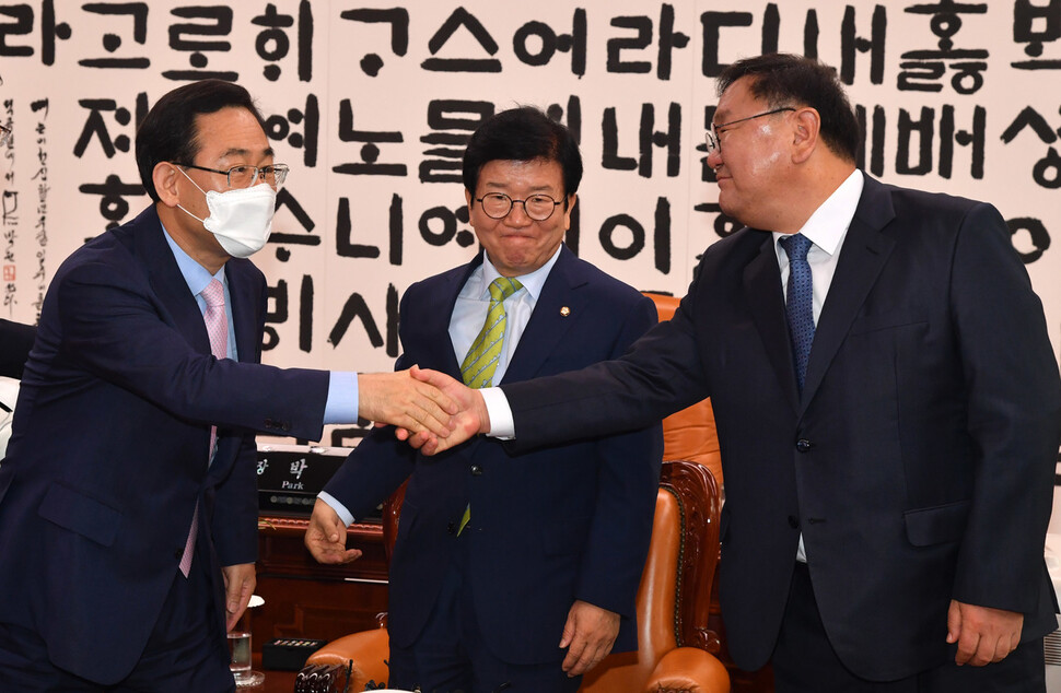 더불어민주당 김태년 원내대표(오른쪽)와 미래통합당 주호영 원내대표(왼쪽)가 이 11일 오전 서울 여의도 국회 국회의장실에서 열린 21대 국회 전반기 원구성 협상을 위한 국회의장 주재 원내대표 회동에서 악수하고 있다. 가운데는 박병석 국회의장. 연합뉴스