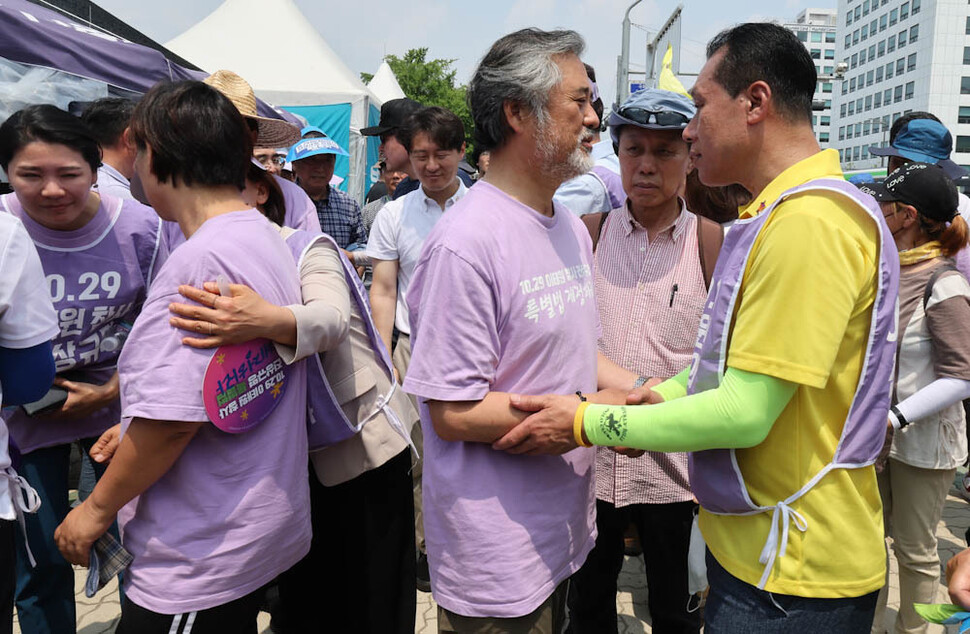 9일째 단식농성 중인 고 이주영씨의 아버지 이정민(가운데)씨가 28일 오후 행진을 마친 김종기 4·16세월호참사가족협의회 운영위원장과 인사하고 있다. 김정효 기자