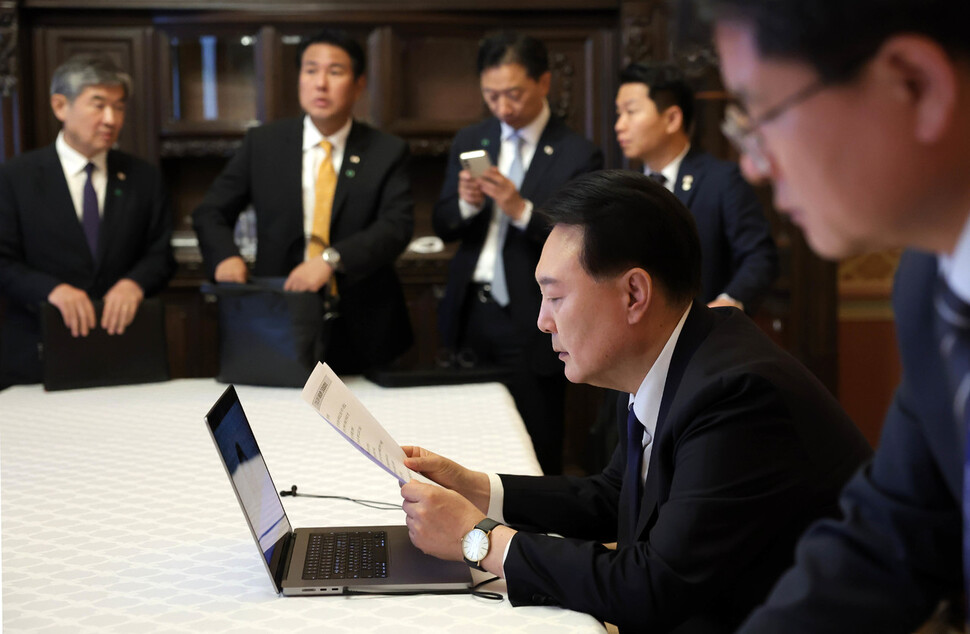 윤석열 대통령이 볼로디미르 젤렌스키 우크라이나 대통령과의 정상회담 직후인 15일(현지시각) 현지에서 중앙재난안전대책본부와 화상 연결해 한덕수 국무총리로부터 호우 피해 상황 보고를 받은 후 대응을 지시하고 있다. 대통령실 제공