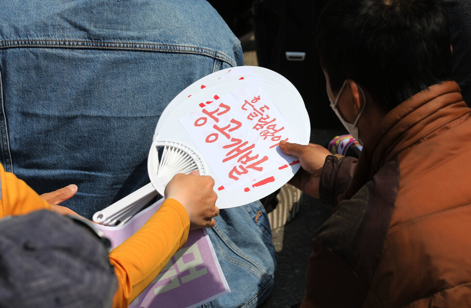 ‘동자동 쪽방촌 선이주선순환 공공주택지구지정 촉구 주민결의대회’가 시작하기 전 ‘흔들림 없이 공공개발!’이라고 적힌 부채를 참석자들이 나눠가지고 있다. 김혜윤 기자