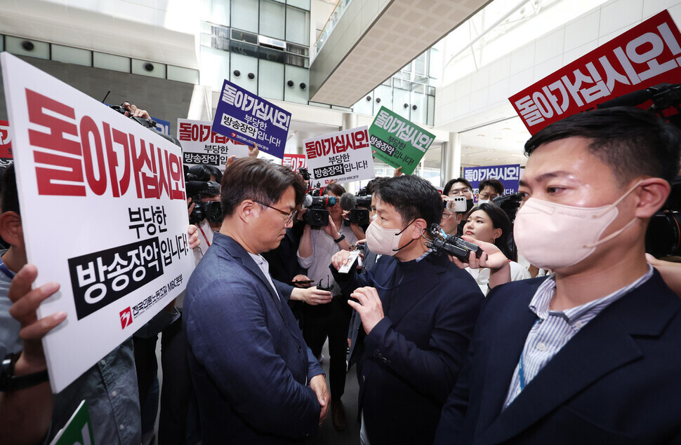 지난달 30일 &lt;문화방송&gt;(MBC) 뉴스룸 압수수색에 나선 경찰(오른쪽)이 항의하는 직원들에게 신분증을 내밀며 뉴스룸 진입을 시도하고 있다. 연합뉴스