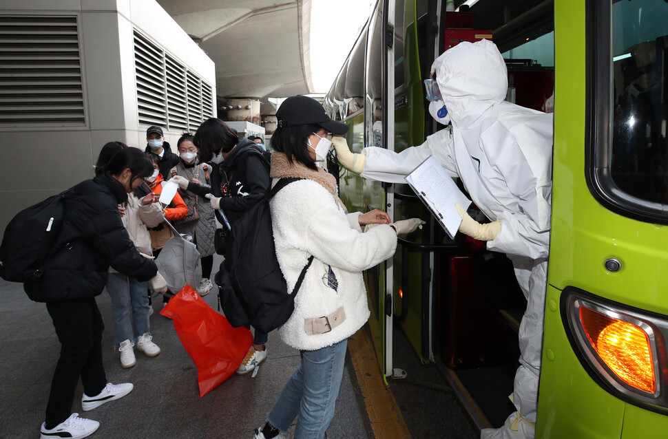 배재대학교 대외협력팀 관계자들이 24일 오후 인천국제공항 제1터미널 들머리에서 이날 중국에서 입국한 유학생들에게 새 마스크와 장갑을 제공하고 있다. 학생들은 중국에서 착용하고 온 마스크, 장갑 등을 모두 버리고 체온 측정을 받은 뒤에야 버스에 오를 수 있었다. 인천공항/백소아 기자 thanks@hani.co.kr