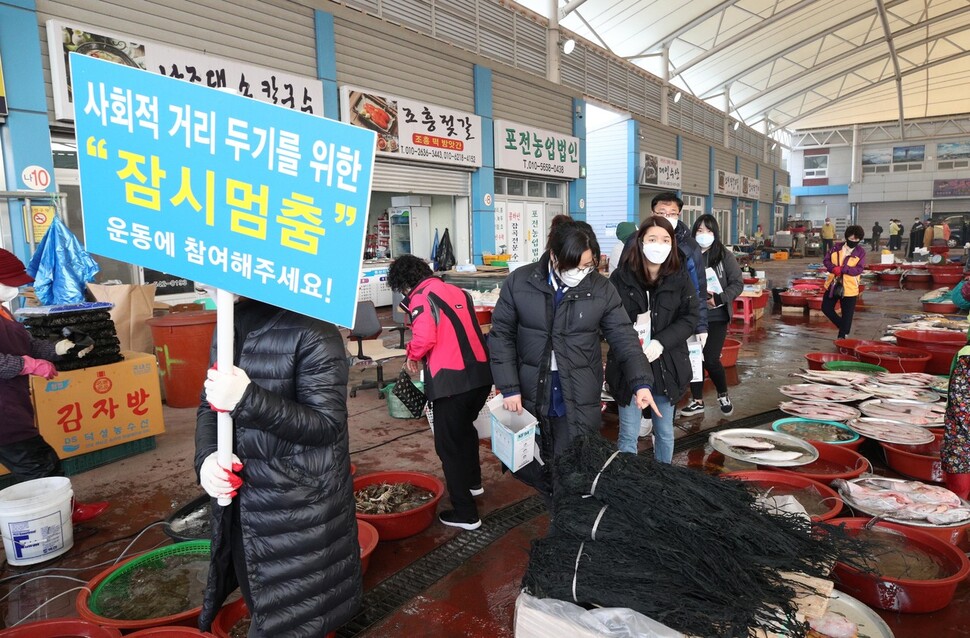 전남 진도군청 직원들이 7일 오전 읍내 5일장터인 조금시장에서 코로나19 감염 예방을 위한 사회적 거리두기 홍보와 상인들에게 마스크를 나눠주고 있다. 진도/김봉규 선임기자